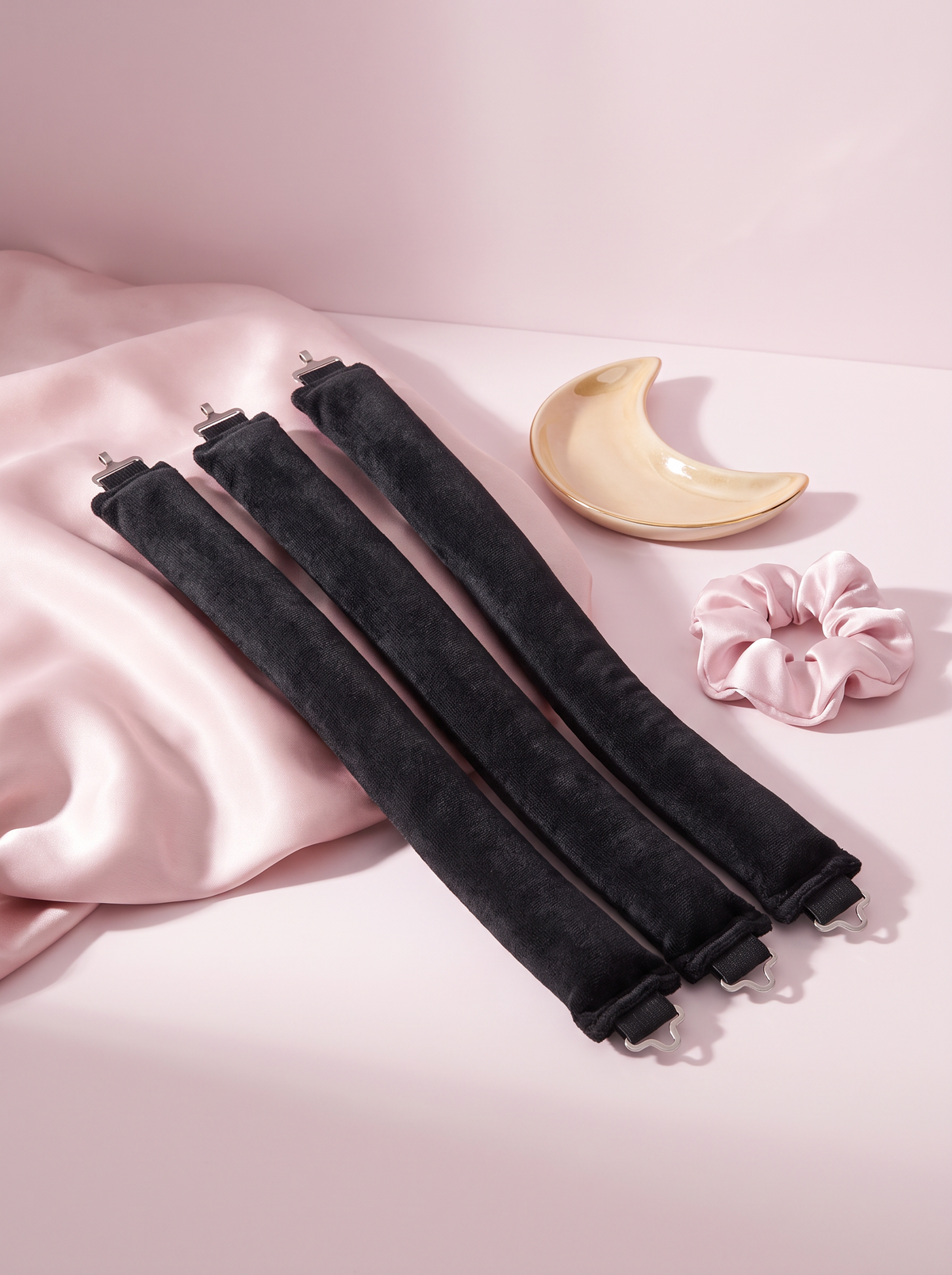 Trois bigoudis sans chaleur Onduluna sur satin rose